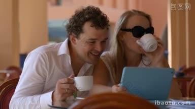 年轻的情侣在咖啡馆<strong>喝茶</strong>，在平板电脑上看东西